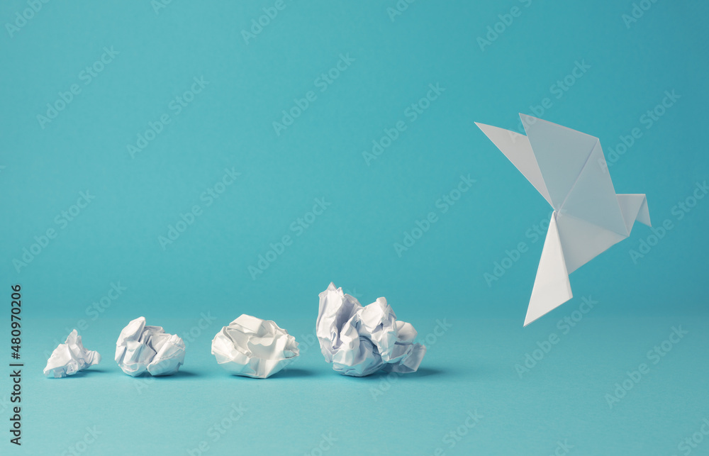 Crumpled paper balls with an origami paper dove, peace, freedom or opportunities - obrazy, fototapety, plakaty 