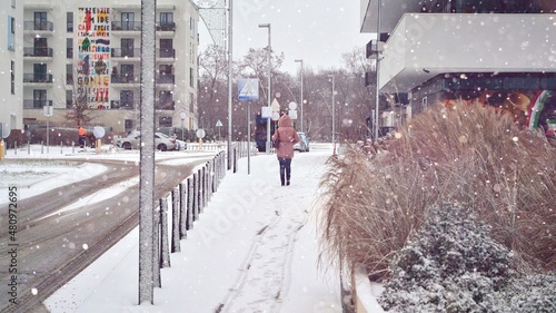 A girl with walks down the street during a heavy snowfall photo