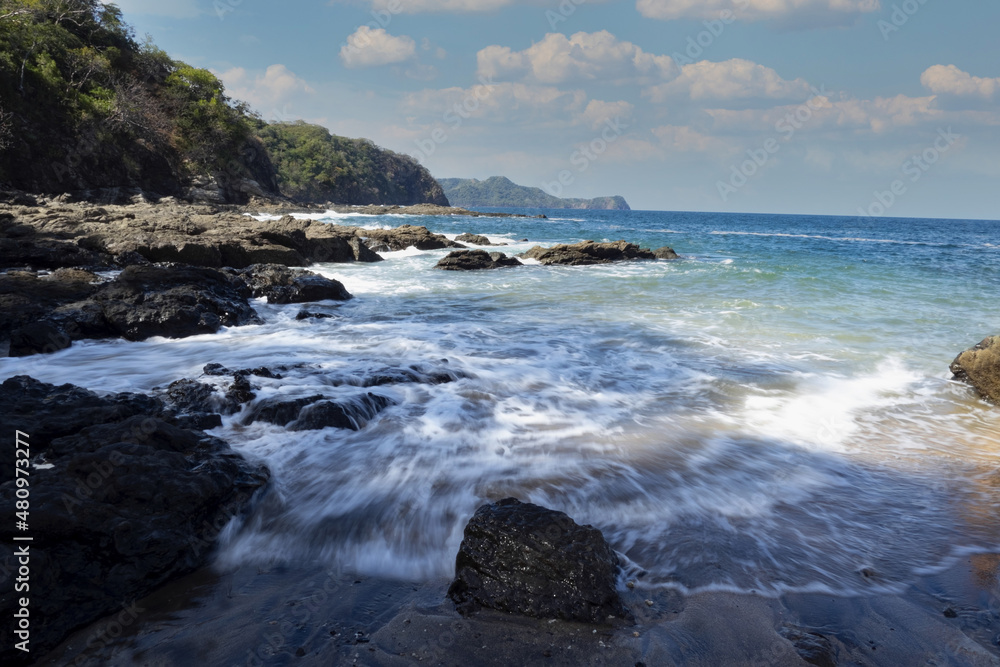 Obraz premium The waves are breaking on the rocky Pacific coast. Costa Rica