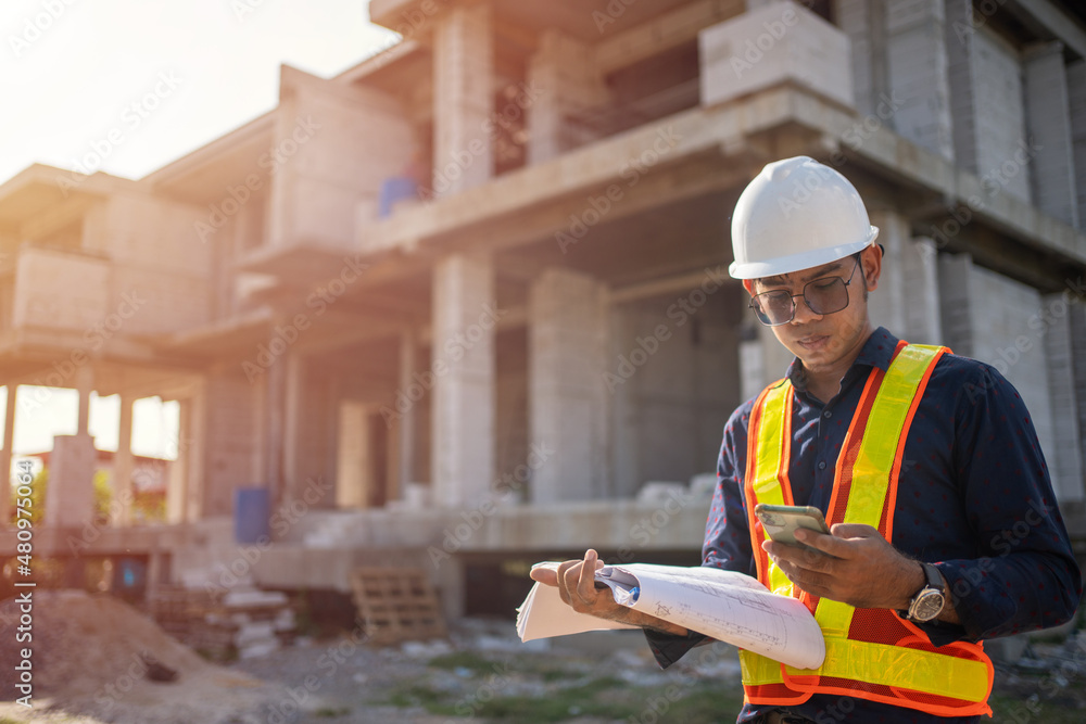 Engineer using smart phone talk with team for checking with blueprints on construction site Engineer using smart phone talk with team for checking with blueprints on construction site