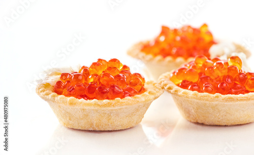 Red caviar in tartlets over white background. Close-up salmon caviar. Delicatessen. Gourmet food. Texture of caviar. Seafood