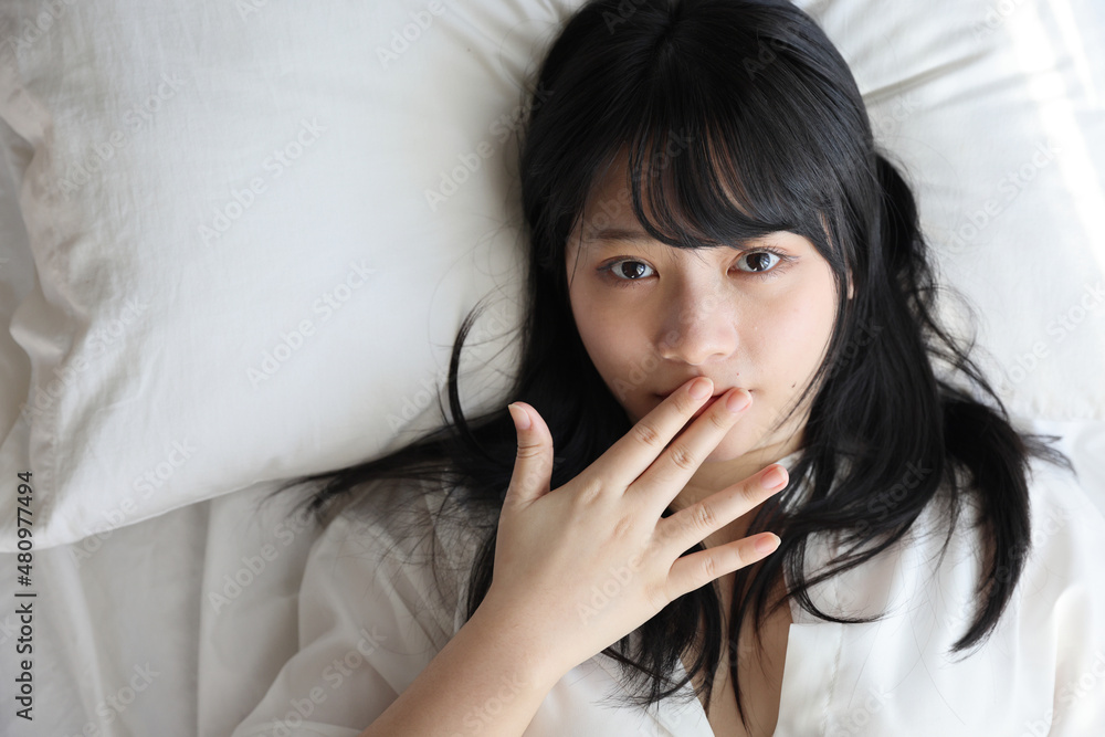 Beautiful young woman waking up in the morning at white bedroom Beautiful young woman waking up in the morning at white bedroom