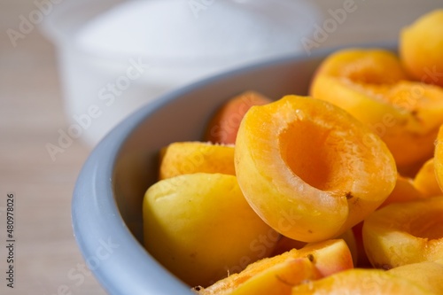 Close-up of apricot halves in a bowl, preparation for making preserves or jam