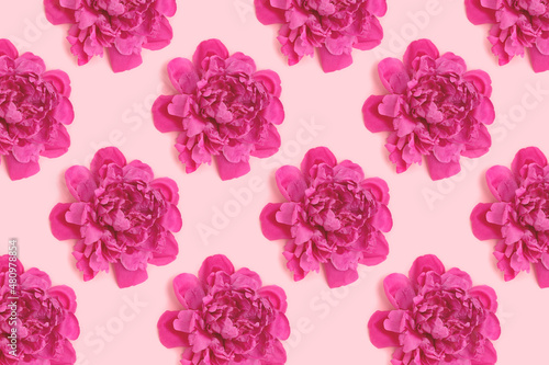 Repetitive pattern made of heads of peony flower on a pink pastel background. Creative concept.