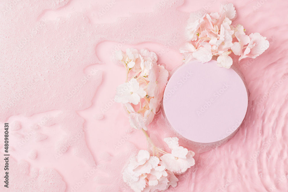 Top view of pink transparent clear calm water surface. Texture with splashes, foam and bubbles with pink podium and flowers. Trendy abstract spring summer nature background. Flat lay cosmetic mockup Top view of pink transparent clear calm water surface. Texture with splashes, foam and bubbles with pink podium and flowers. Trendy abstract spring summer nature background. Flat lay cosmetic mockup