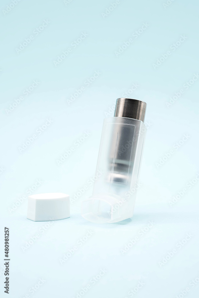 Asthma inhaler on blue background, copy space. Aerosol for inhalation, treatment of bronchial asthma, COPD. Pharmaceutical product for treat lung inflammation and prevent asthma attack. Asthma inhaler on blue background, copy space. Aerosol for inhalation, treatment of bronchial asthma, COPD. Pharmaceutical product for treat lung inflammation and prevent asthma attack.