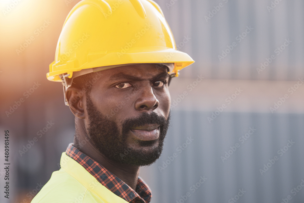 African American worker working in Import-export cargo yard, large-scale transportation via barges African American worker working in Import-export cargo yard, large-scale transportation via barges