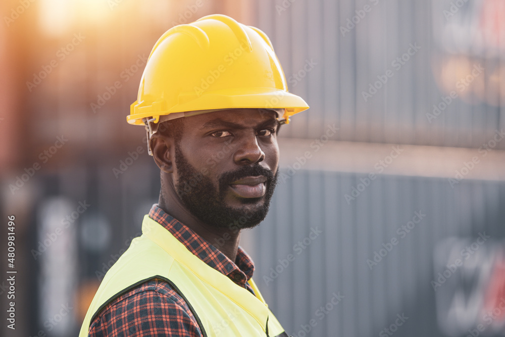 African American worker working in Import-export cargo yard, large-scale transportation via barges African American worker working in Import-export cargo yard, large-scale transportation via barges