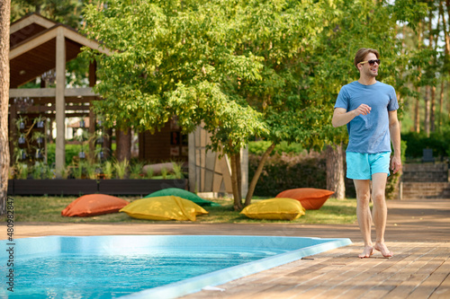 A young man in blue swim shorts at the swimming pool