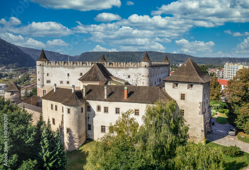 Aerial panorama view of Zvolen medieval castle with turrets and gate house, outer castle buildings in Slovakia blue cloudy sky background