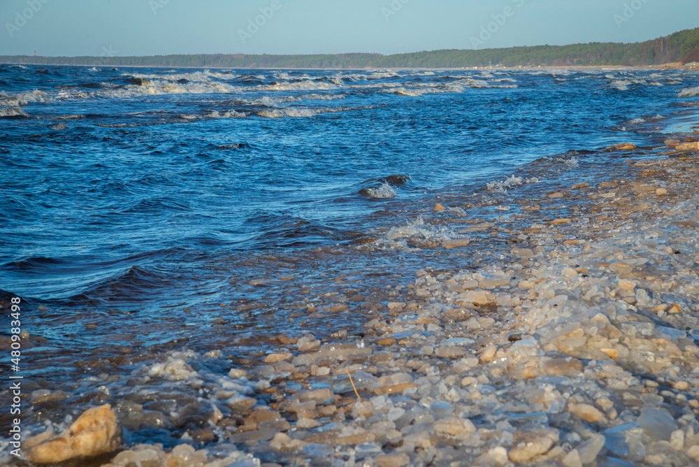 frozen sea side beach panorama in winter with lots of ice and snow in late evening