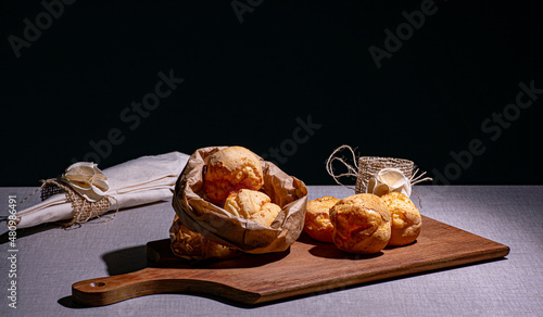 delicioso lanche com pão de queijo que está sobre uma madeira e acompanha um guardanapo photo