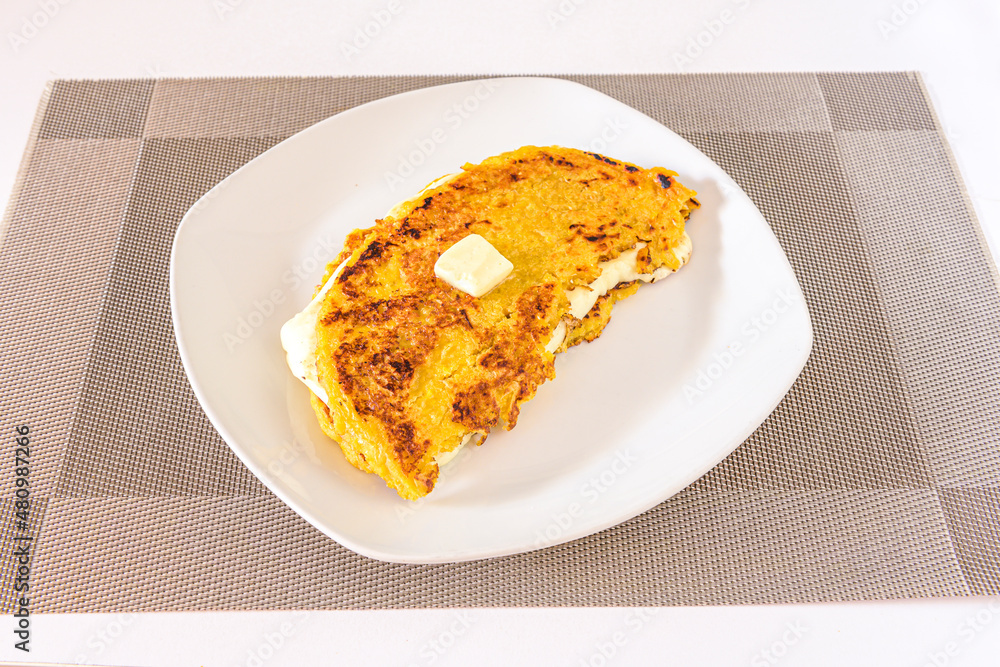 Cachapa is a typical corn-based dish stuffed with fresh cheese on a white plate