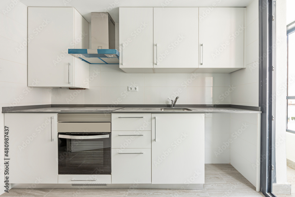 newly fitted white kitchen with gray stone countertops and stainless steel appliances newly fitted white kitchen with gray stone countertops and stainless steel appliances