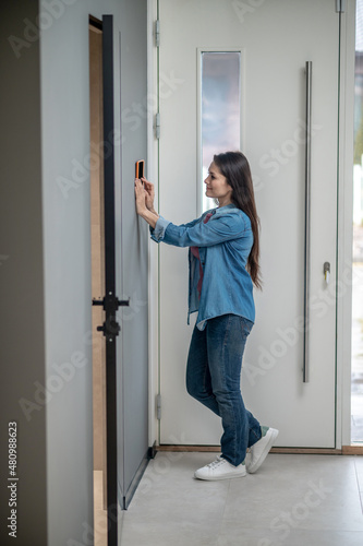 Woman standing sideways to camera near smart home device © zinkevych