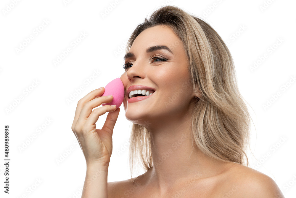 Beautiful woman with a smooth skin holding makeup sponge on white background Beautiful woman with a smooth skin holding makeup sponge on white background