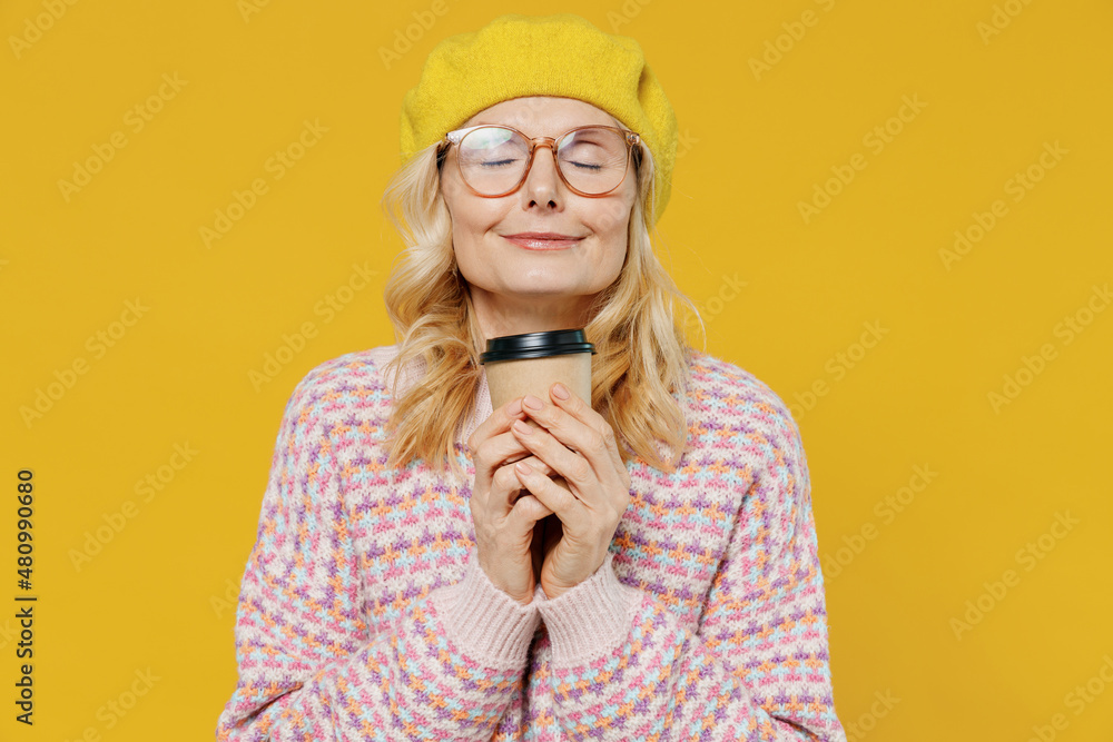 © ViDi Studio - Elderly smiling fashionable positive happy blonde caucasian woman 50s in pink sweater beret hat glasses hold takeaway delivery craft paper brown cup coffee to go isolated on plain yellow background © ViDi Studio - Elderly smiling fashionable positive happy blonde caucasian woman 50s in pink sweater beret hat glasses hold takeaway delivery craft paper brown cup coffee to go isolated on plain yellow background