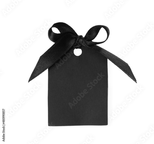 Blank tag with black satin ribbon tied in bow on white background, top view. Space for design