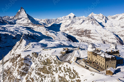Aerial view of the famous Gornergrat ridge and train station with the Matterhorn peak in Zermatt in the alps in Switzerland on a sunny winter day