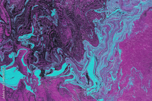 Fluid art. Purple pink turquoise paint mixed. Trendy velvet violet color 2022. A flowing shiny surface. Slow movement, beautiful swirl lines. A fashionable original hobby. Creation of a work of art.