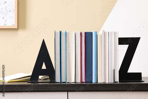 Minimalist letter bookends with books on table indoors