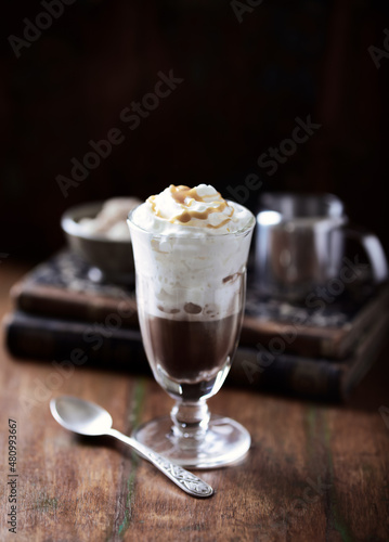 Coffee with whipped cream on dark background. Soft focus. Close up.	
