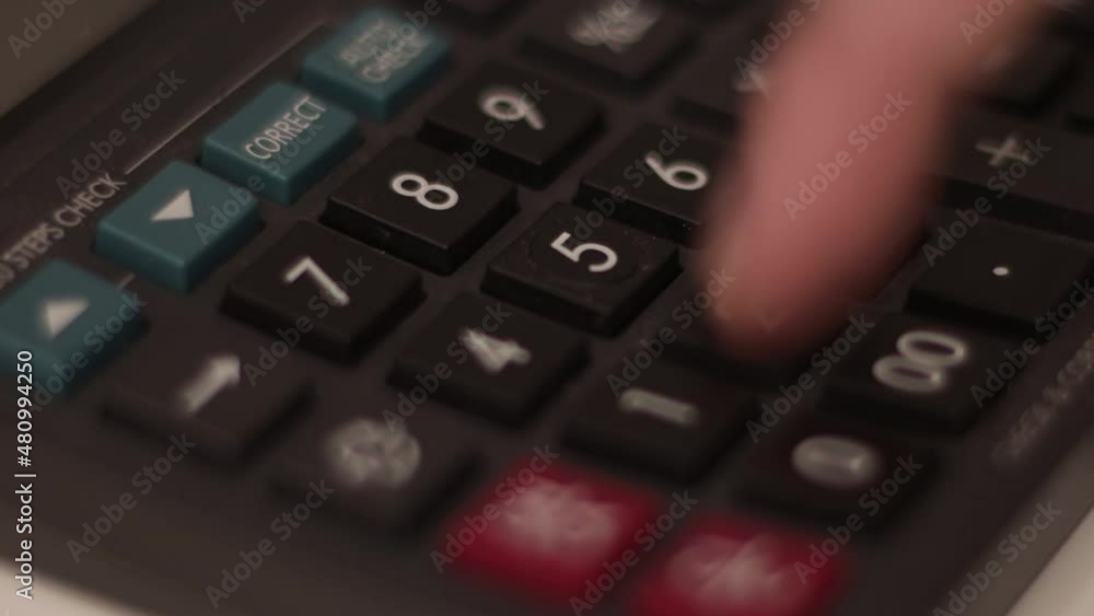 Closeup of man on a calculator. Investment, financial or economy concept, analysis of earnings with digital device on the desk Closeup of man on a calculator. Investment, financial or economy concept, analysis of earnings with digital device on the desk