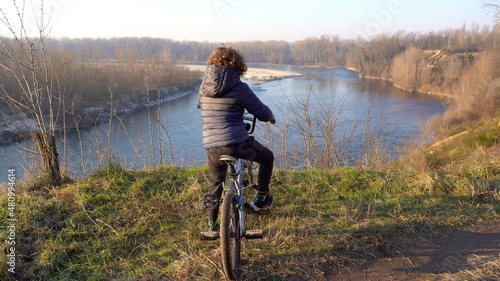 Obraz na płótnie 7 years old boy child drives a bicycle in nature wood near the river in Ticino natural park , Pavia Italy, Europe w salonie