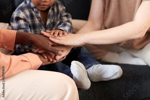 Close-up image of multi-ethnic mothers and little son playing and stacking game at home