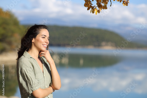 Fotografi Happy woman contemplating views in a lake
