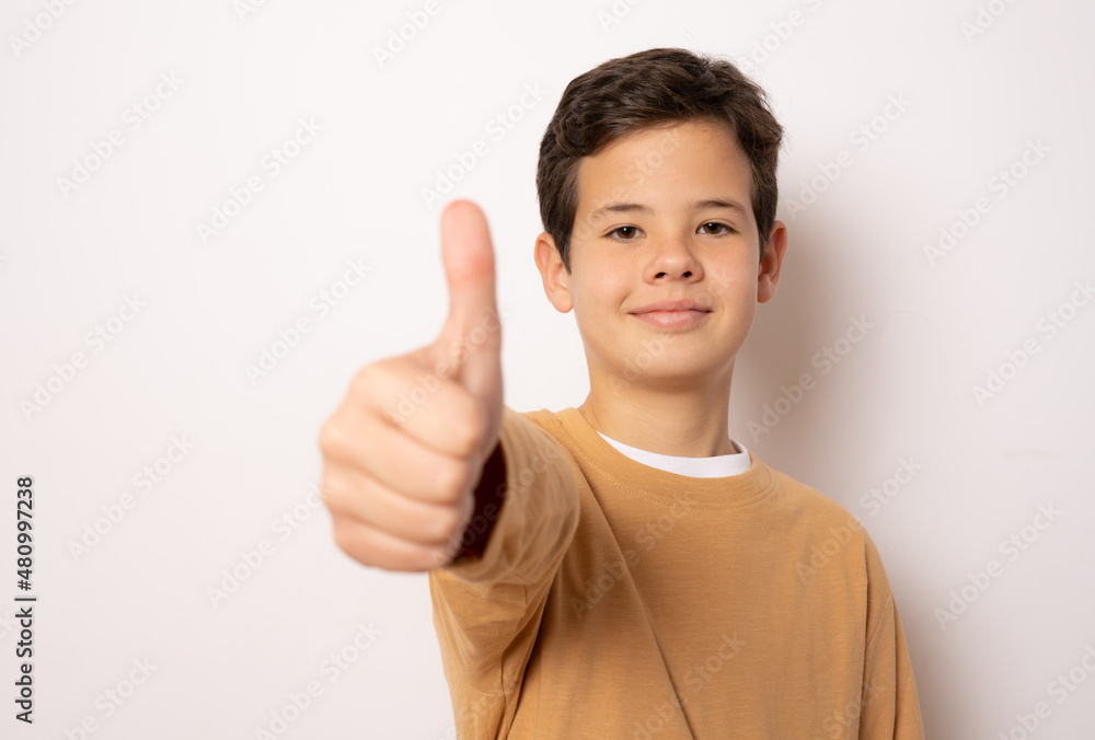 Cute boy showing thumb up over white background. Cute boy showing thumb up over white background.