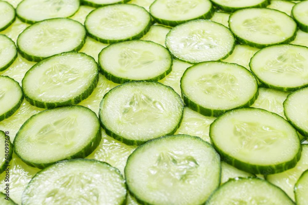 Fresh green slices of cucumber as background. Fresh green slices of cucumber as background.