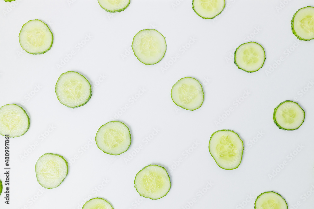 Fresh cucumber round slices on white background, top view.