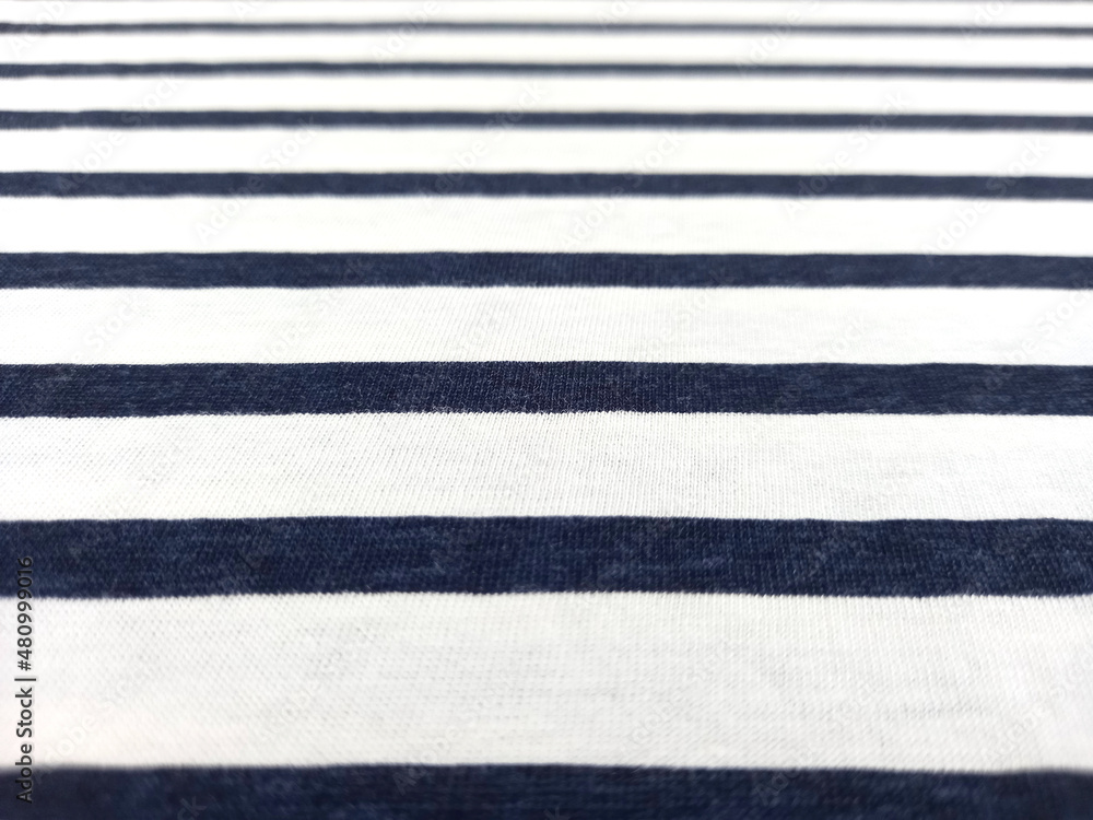 Fototapeta premium Blue and white striped cotton fabric background. Horizontal striped cotton texture perspective view.