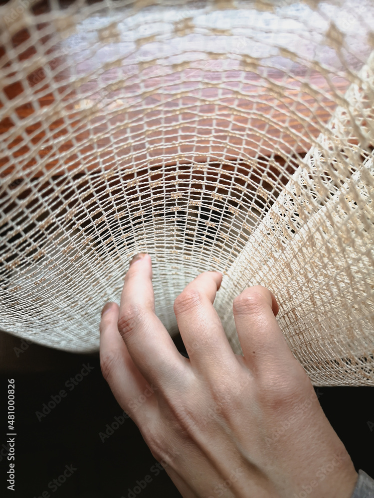 Woman's hand touches the curtain on the window Woman's hand touches the curtain on the window