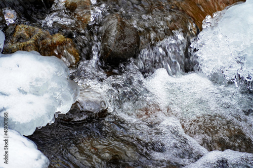 coarse flowing water  frozen current  winter brook 