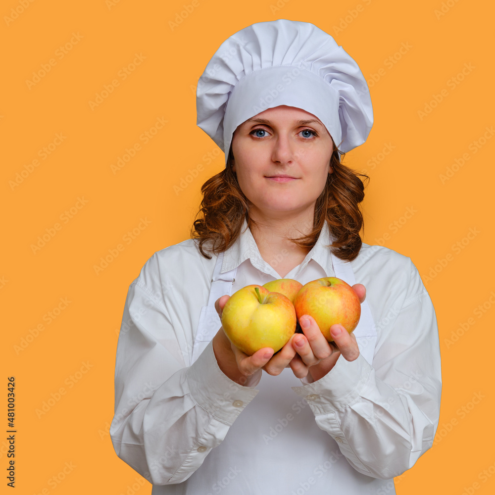 Happy woman chef with apples in hands on studio background, copy space Happy woman chef with apples in hands on studio background, copy space