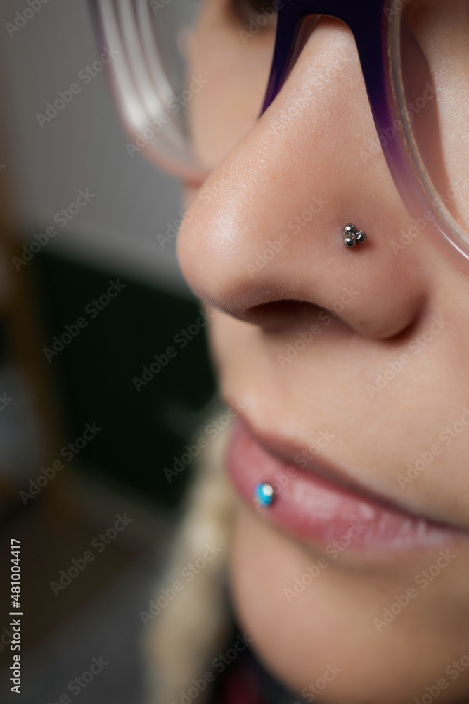 Closeup of a woman's visage with piercing septum hanging from her nose. Stock-foto | Adobe Stock