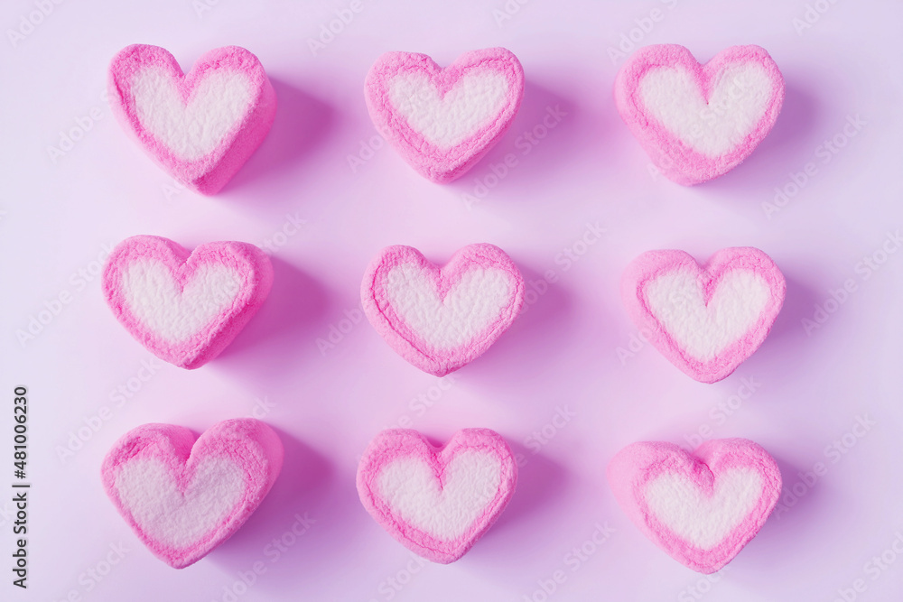 Rows of Pink and White Heart Shaped Marshmallow Candies on Pink Background