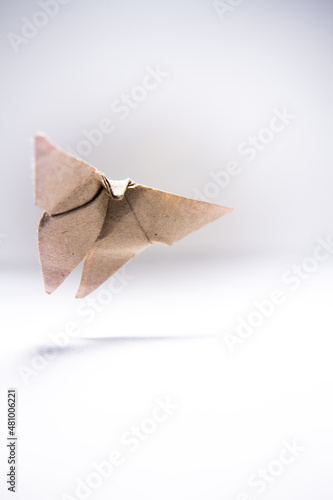 origami butterfly made of gray paper soars in the air