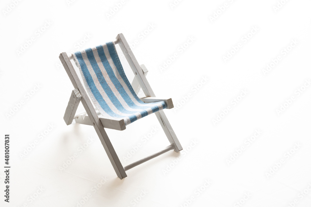 Deck chair, white blue striped beach chair isolated on white background.
