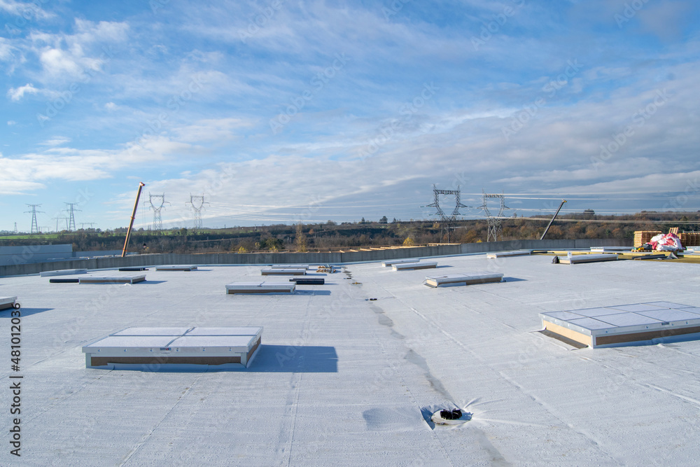 Construction of a flat roof with EPDM (ethylene propylene diene monomer) membrane on a large warehouse - obrazy, fototapety, plakaty 