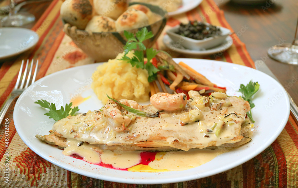 Plate of Delectable Pan-seared Lake Trout with Creamy Shrimp Sauce Served on Country Style Table Plate of Delectable Pan-seared Lake Trout with Creamy Shrimp Sauce Served on Country Style Table