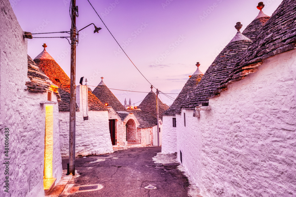 Fototapeta premium Famous Trulli Houses in Alberobello Illuminated at Dusk, Puglia