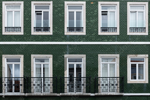 Close-up of traditional apartment building with green tiles facade