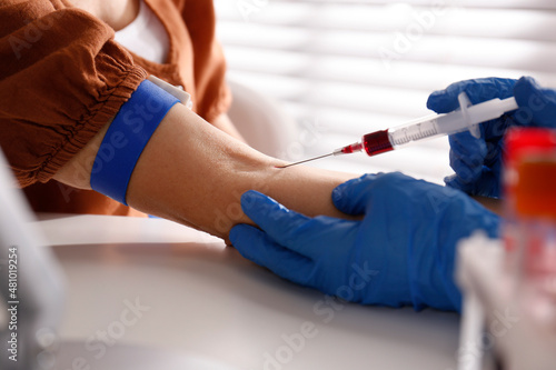 Nurse drawing blood sample from patient in clinic  closeup