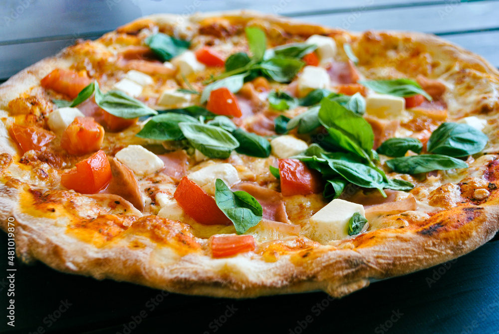 Close-up of fresh pizza with cherry tomatoes, feta and basil leaves Close-up of fresh pizza with cherry tomatoes, feta and basil leaves