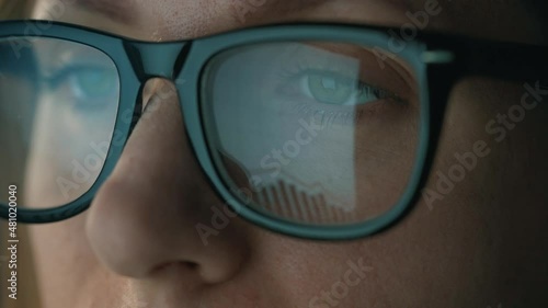 Wallpaper Mural Woman in glasses looking on the monitor and and working with charts and analytics. The monitor screen is reflected in the glasses. Work at night. Extreme close-up Torontodigital.ca