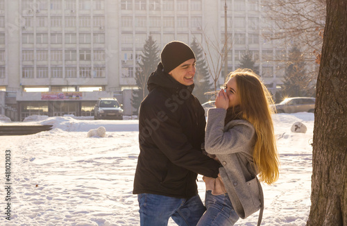 Obraz na płótnie A guy and a girl are indulge and laugh in the winter park w salonie