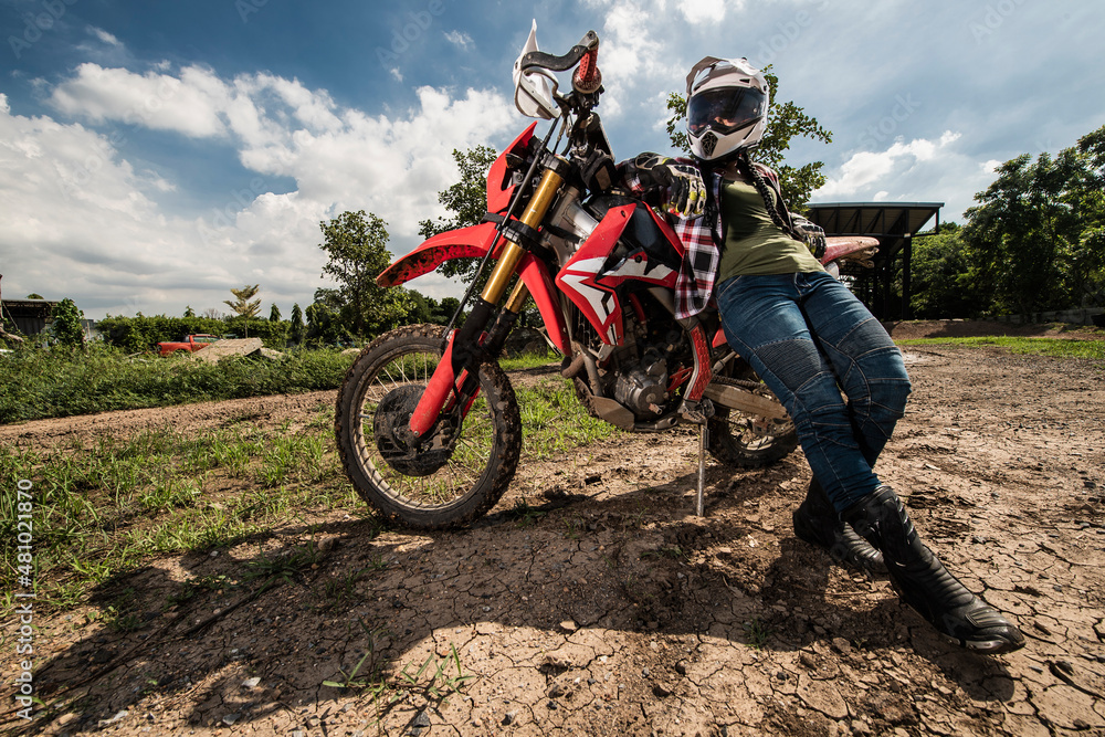 woman leaning on her dirt bike on race track woman leaning on her dirt bike on race track